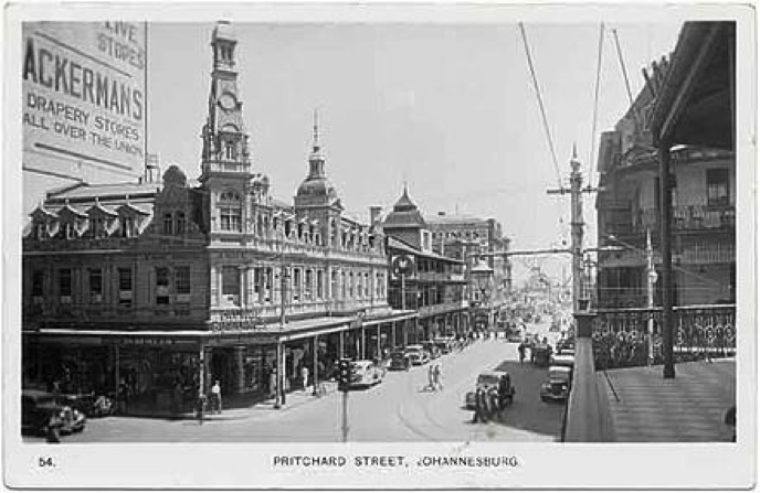 Das Stadtzentrum von Johannesburg, 1910: Links im Bild Ackermans Department Store, eine von zwei jüdischen Einwanderern gegründete Kaufhauskette, damals ein leuchtendes Symbol für Einwanderer, die es geschafft hatten. Foto: © Public domain postcard