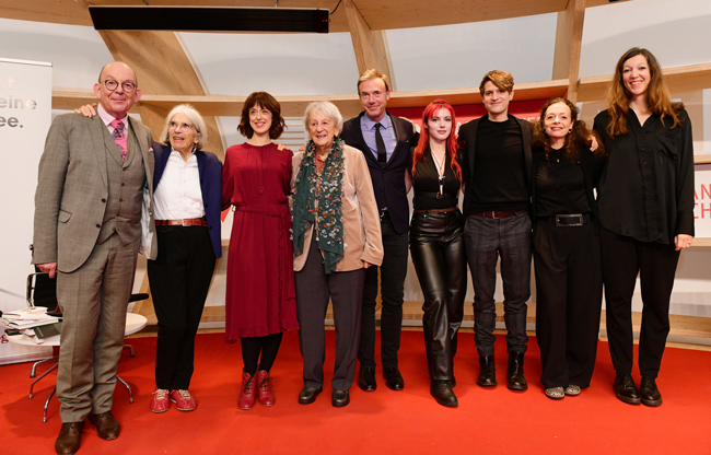 (v. l. n. r.) Denis Scheck, Donna Leon, Irene Vallejo, Ingrid Noll, Philipp Keel, Solomonica de Winter, Benedict Wells, Shelly Kupferberg und Stefanie vor Schulte nach dem 70 Jahre Diogenes Talk © Diogenes / picture alliance / Frank May